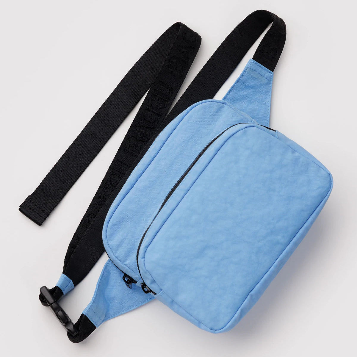 Blue waist bag with a black strap on a light gray background