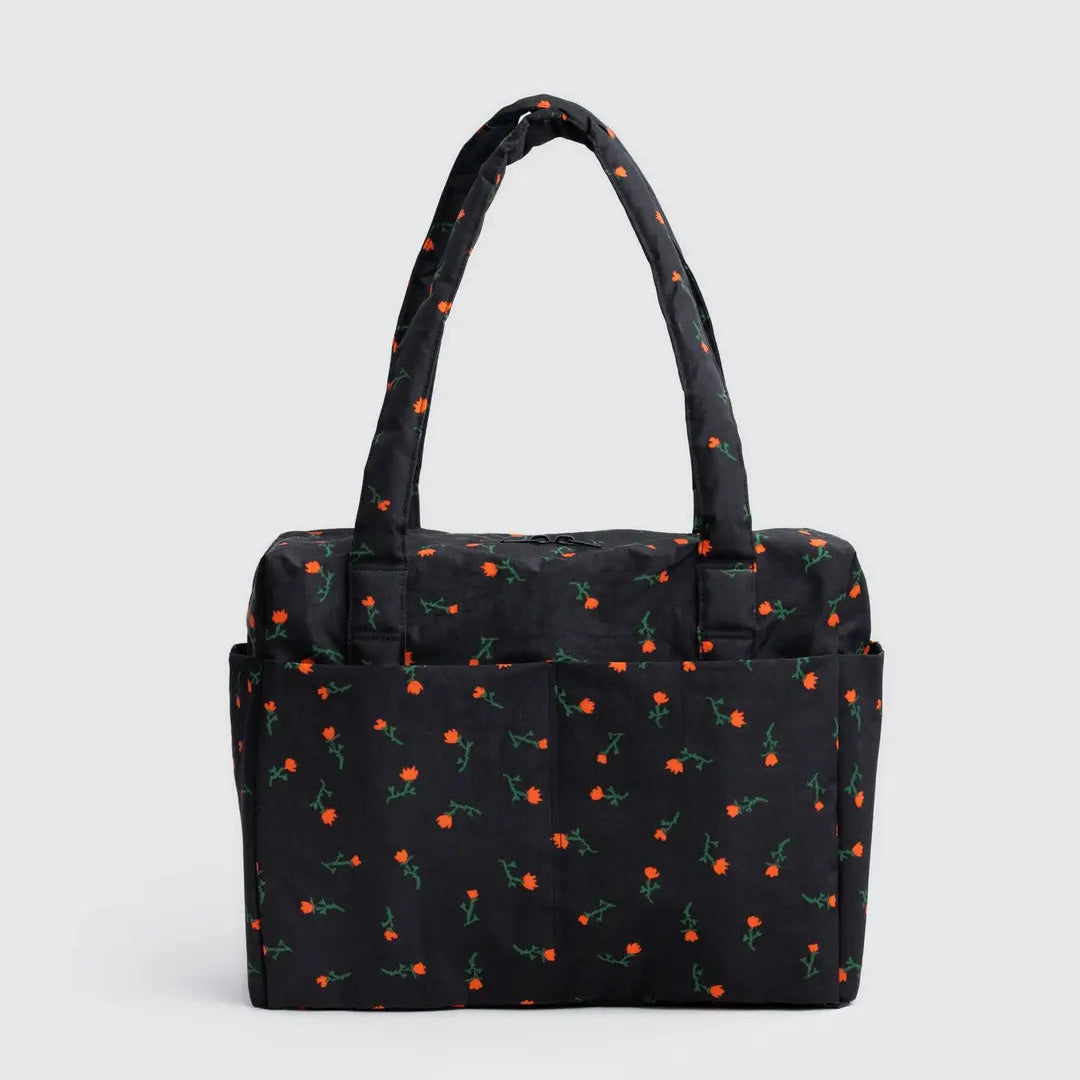 Black handbag with red cherry pattern on a light gray background