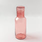 Pink glass bottle on a white background