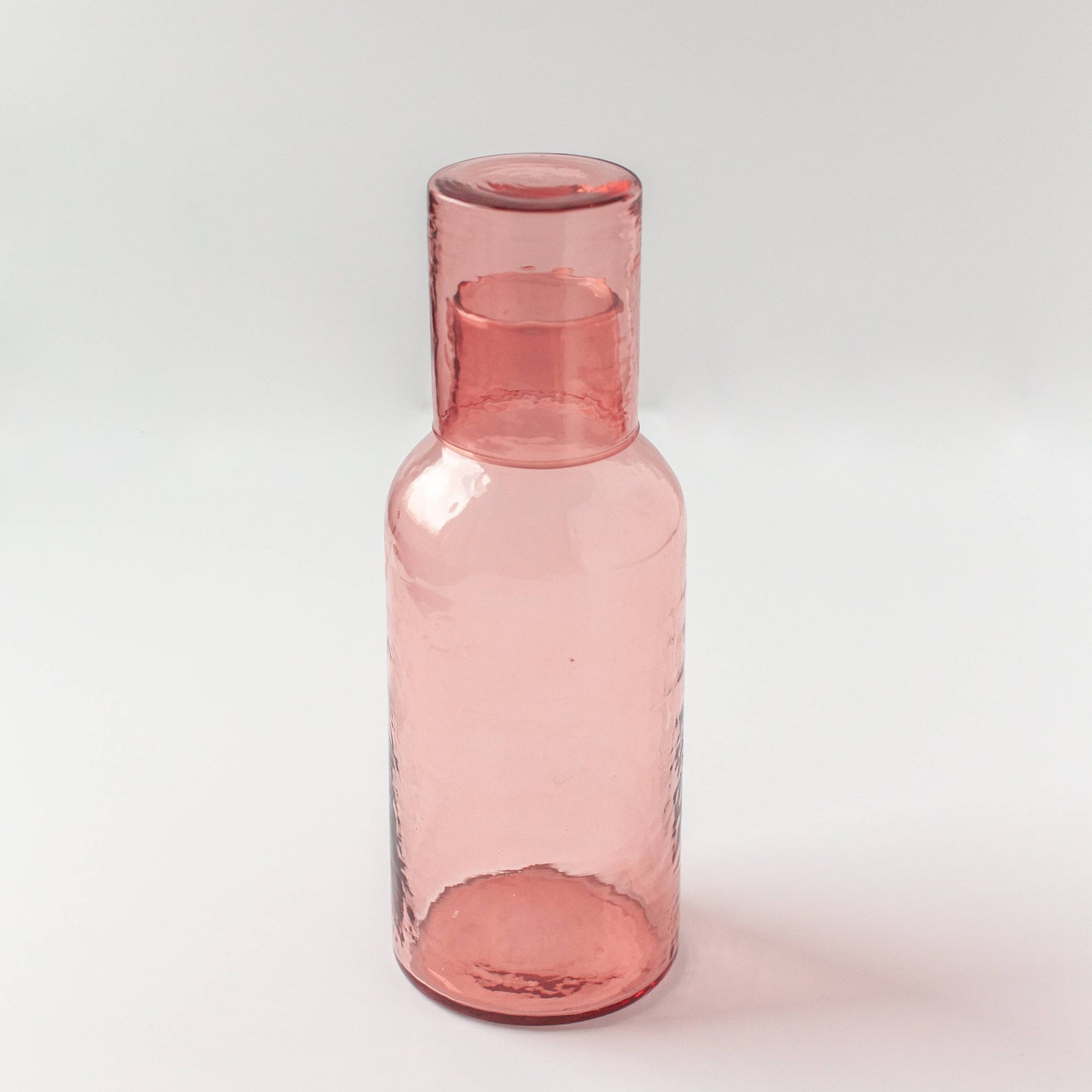 Pink glass bottle on a white background
