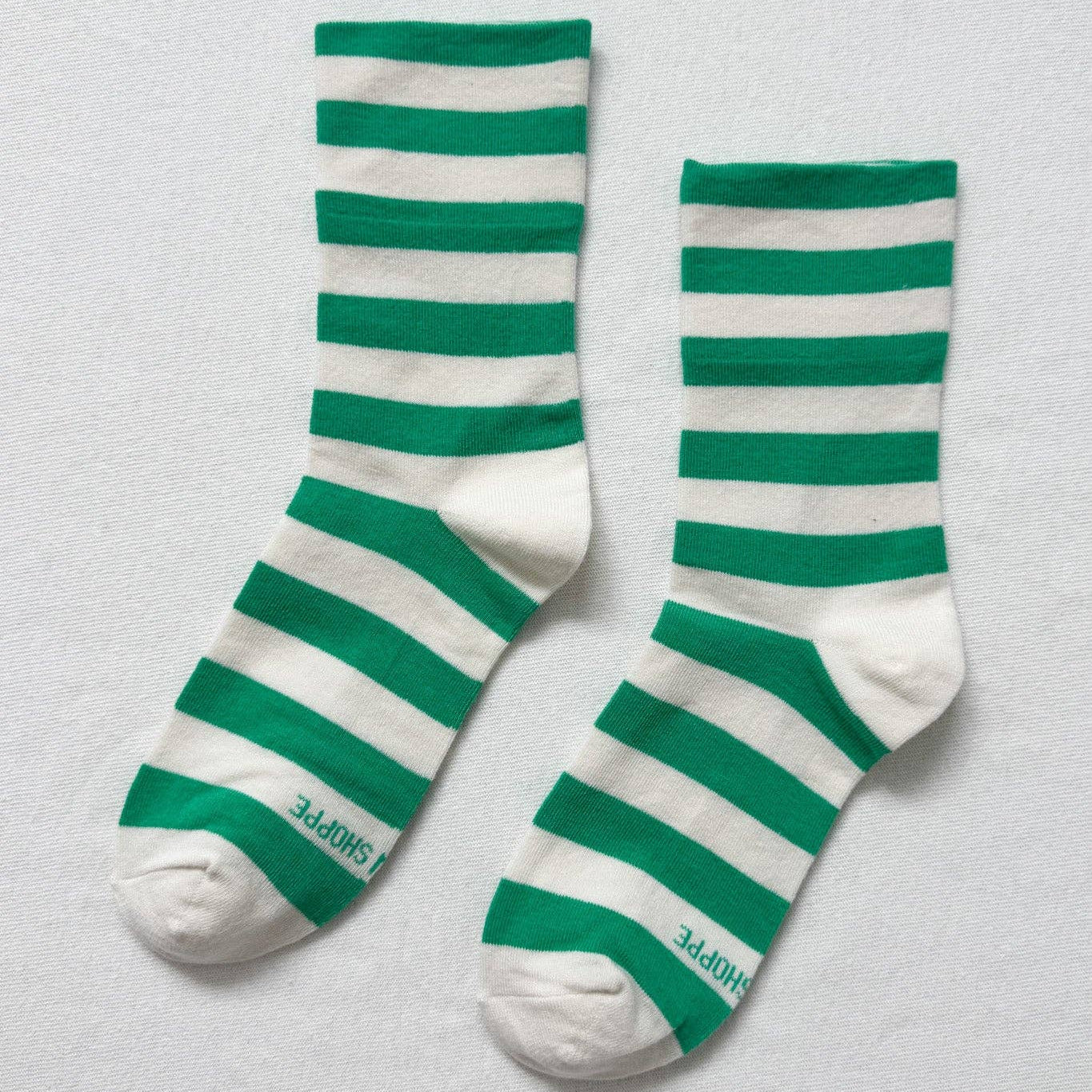 Green and white striped socks on a light gray background