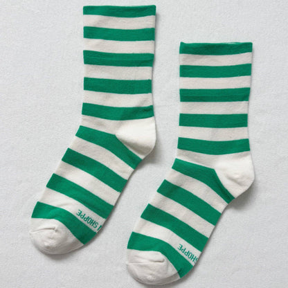 Green and white striped socks on a light gray background