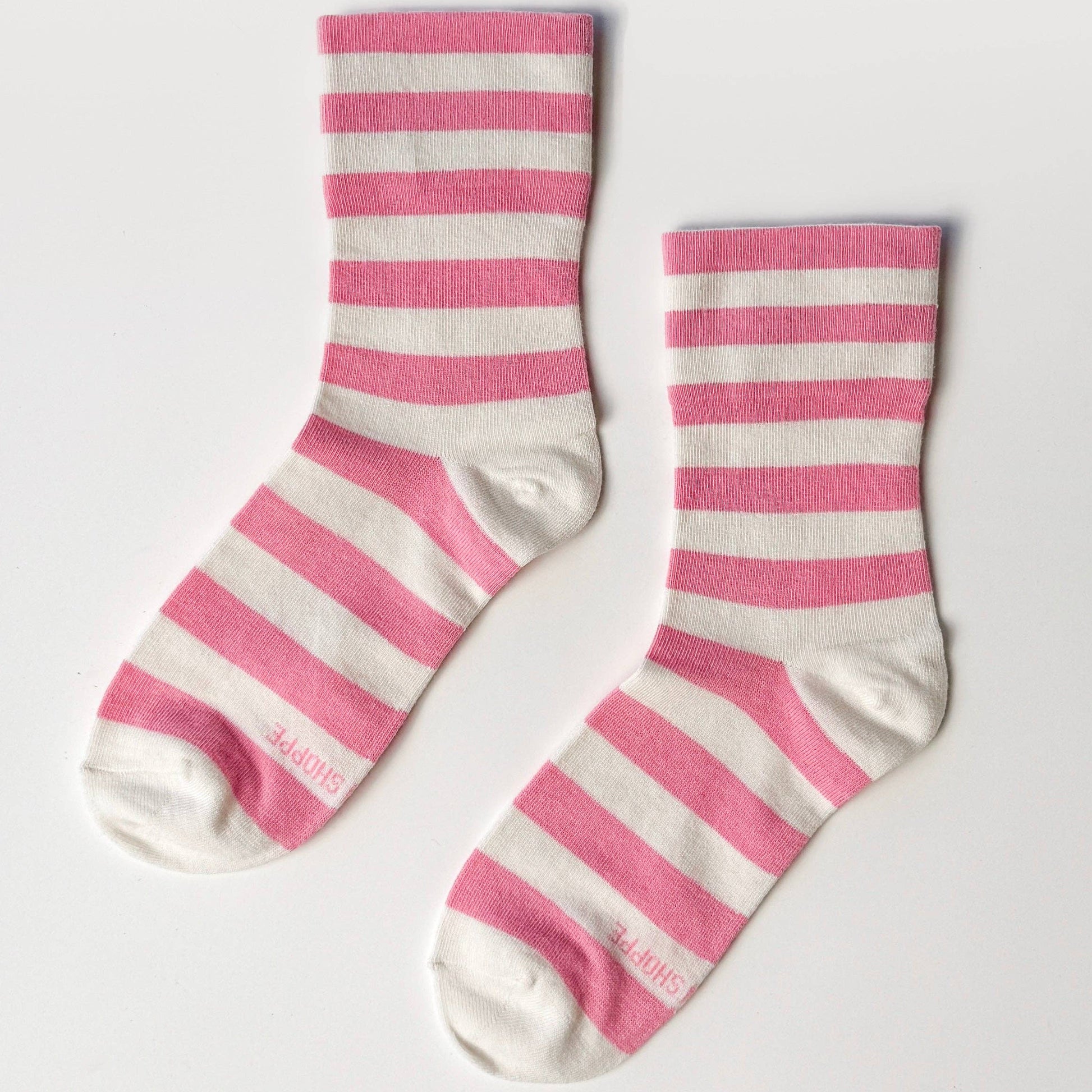 Pair of pink and white striped socks on a light gray background